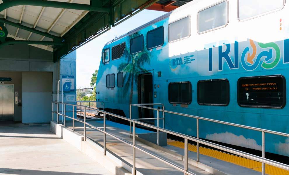 Un tren azul que viaja a lo largo de una ruta panorámica, mostrando su color vibrante contra el paisaje.
