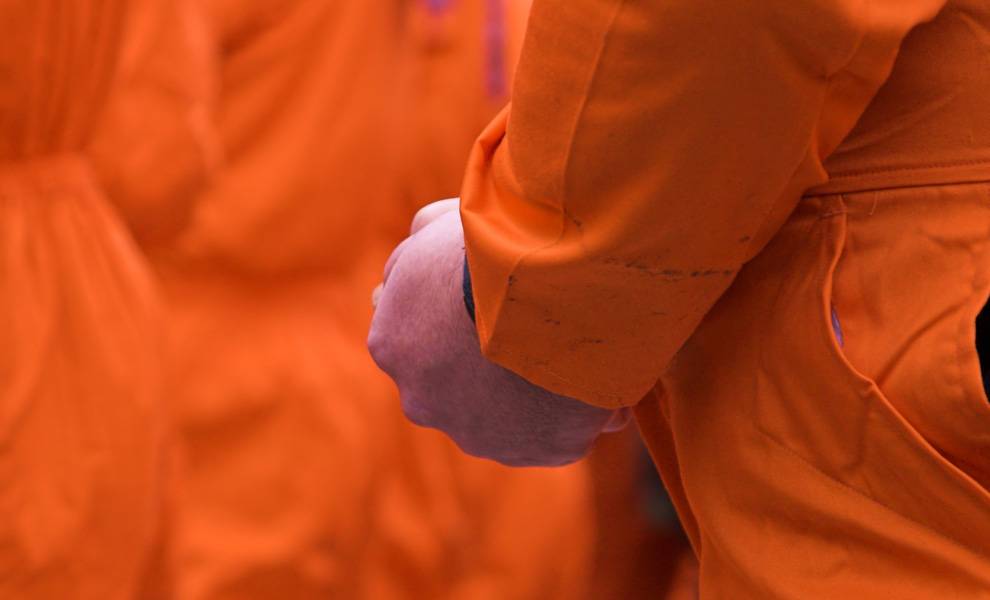 Un hombre vestido con un mono naranja en la Bahía de Guantánamo.