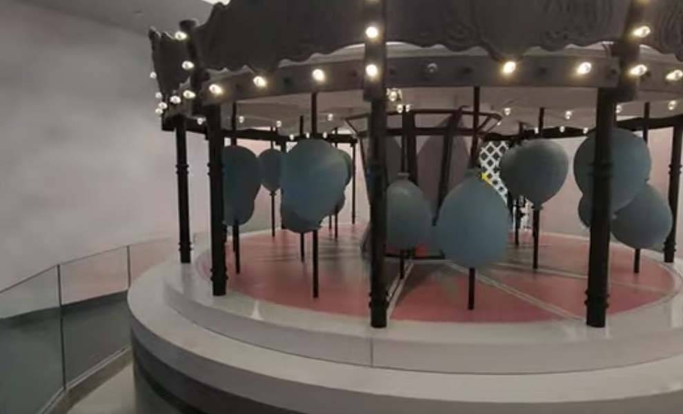 Un colorido carrusel adornado con vibrantes globos azules en el Museo Paradox.