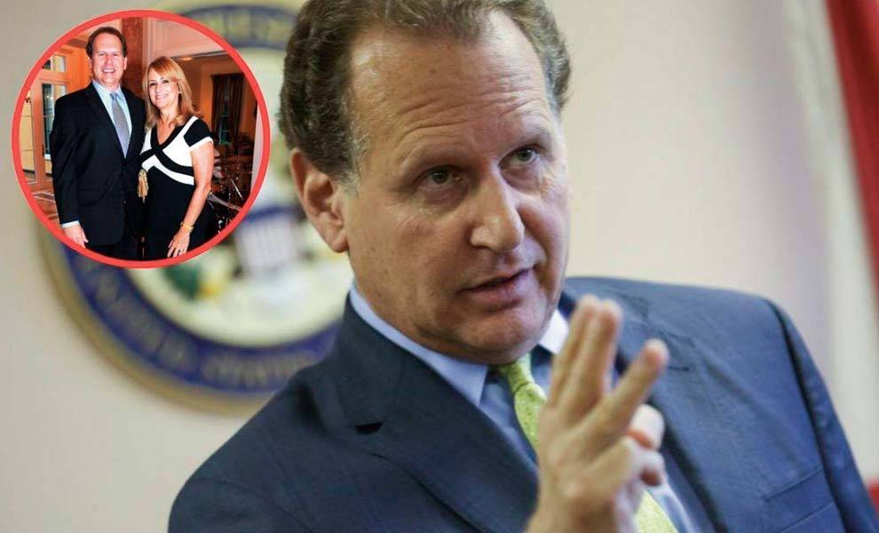 Un hombre con traje y corbata está junto a una mujer; ambos parecen profesionales y conversan.