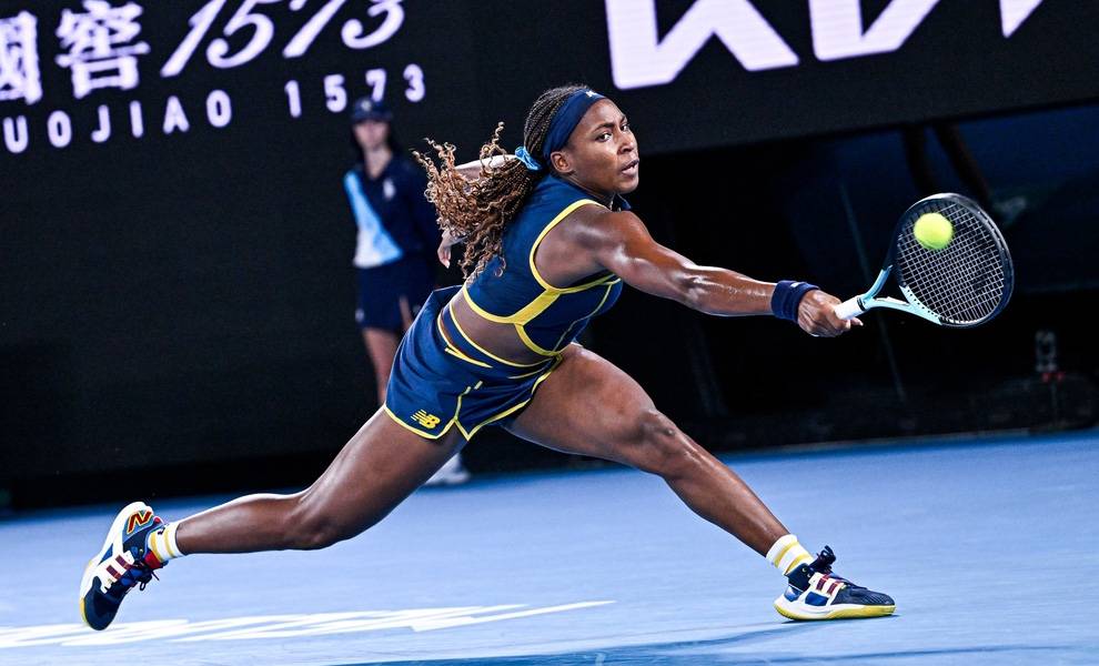 La tenista Coco Gauff, vestida con un atuendo azul y amarillo, está jugando activamente al tenis en una cancha.