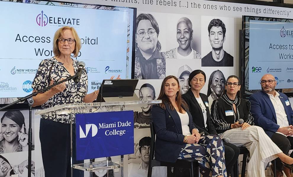 Commissioner Eileen Higgins speaks at a podium while a group of people listens attentively in the background.