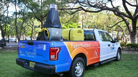 Miami-Dade County Mosquito Control truck under a tree in a park.