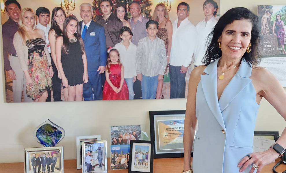 Ana Veiga Milton standing in front of a wall of pictures.