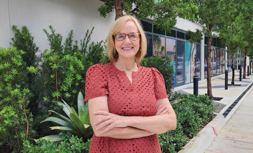Commissioner Eileen Higgins standing in front of shrubs and trees on a sidewalk.