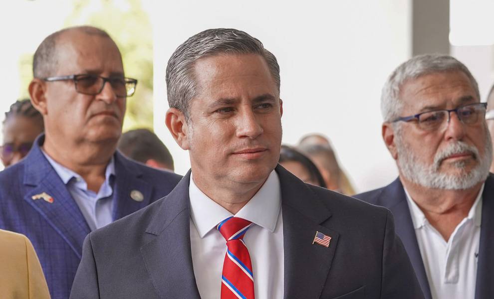 Dariel Fernandez sets January tone with countywide push for fairness, enforcement, and modernization 1 Miami-Dade County Tax Collector Dariel Fernandez standing with a group of people in a blue suit and red tie.