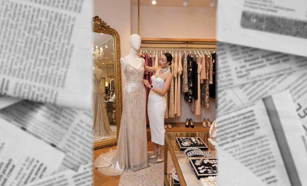 Yli Liriano standing in front of a mannequin adjusting a gown.