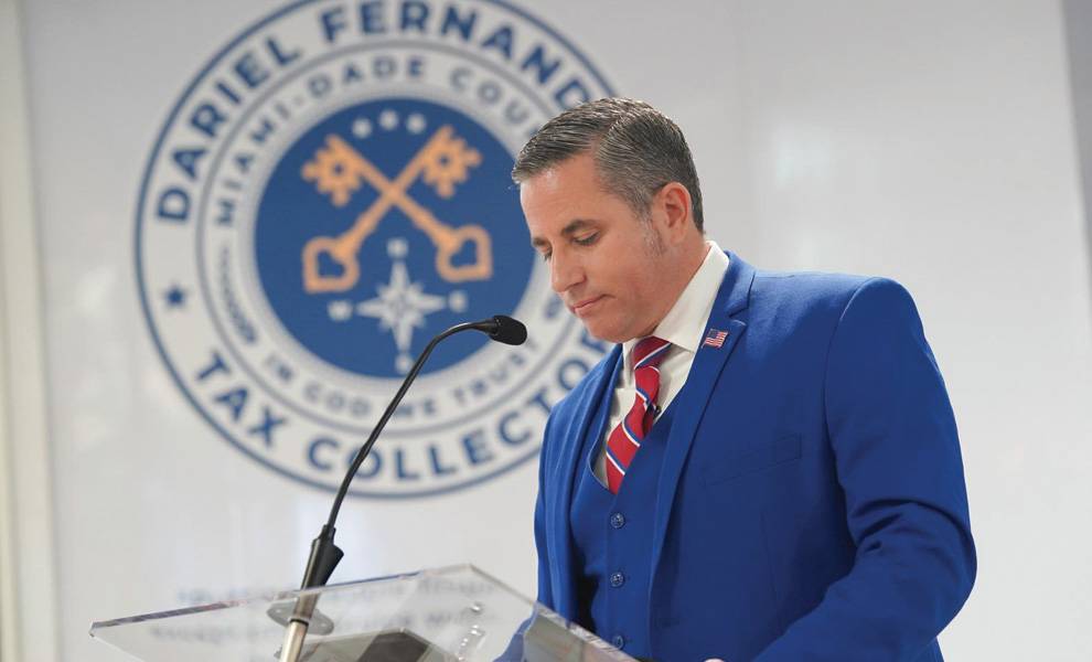 Miami-Dade County Tax Collector Dariel Fernandez speaking at a podium.