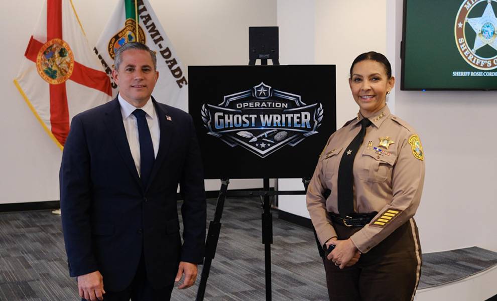 Miami-Dade Tax Collector Dariel Fernandez and Sheriff Rosie Cordero Stutz standing in front of a sign for Operation Ghost Writer.