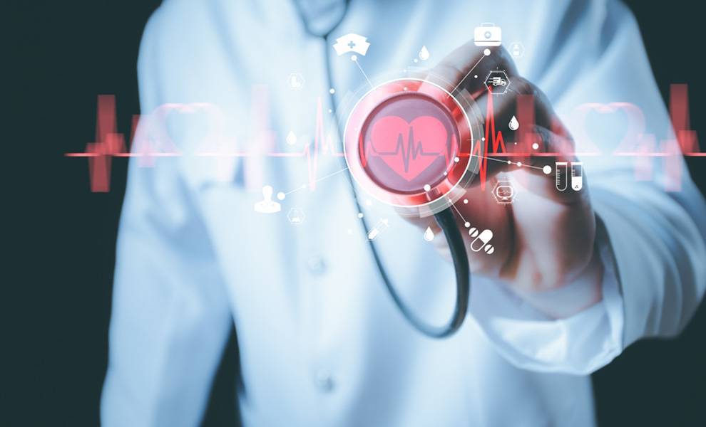 A doctor holding up a stethoscope with a red heart for Heart Health Month.