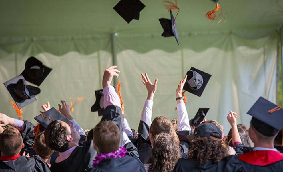 Graduated at FIU throwing their caps after graduation.
