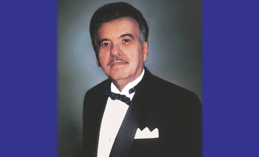 José Milton, de cabello oscuro y bigote, vistiendo un esmoquin negro con pajarita y pañuelo blanco en el bolsillo, posó frente a un fondo neutro.