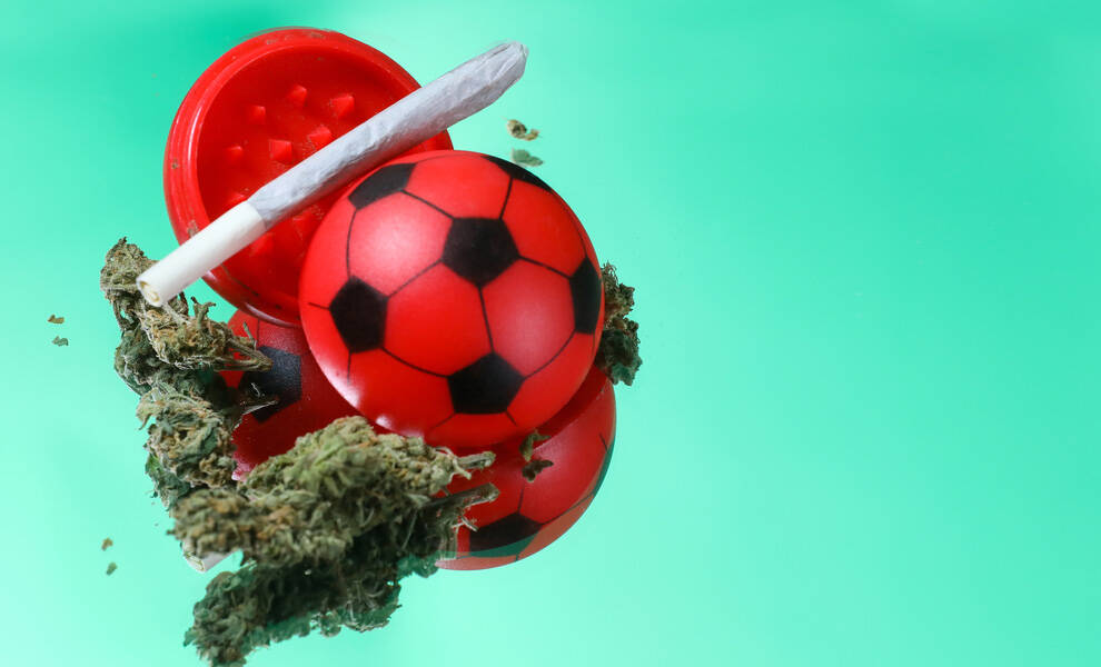 Cannabis, un porro y un grinder rojo estilo balón de fútbol, ​​aislados sobre un fondo verde.