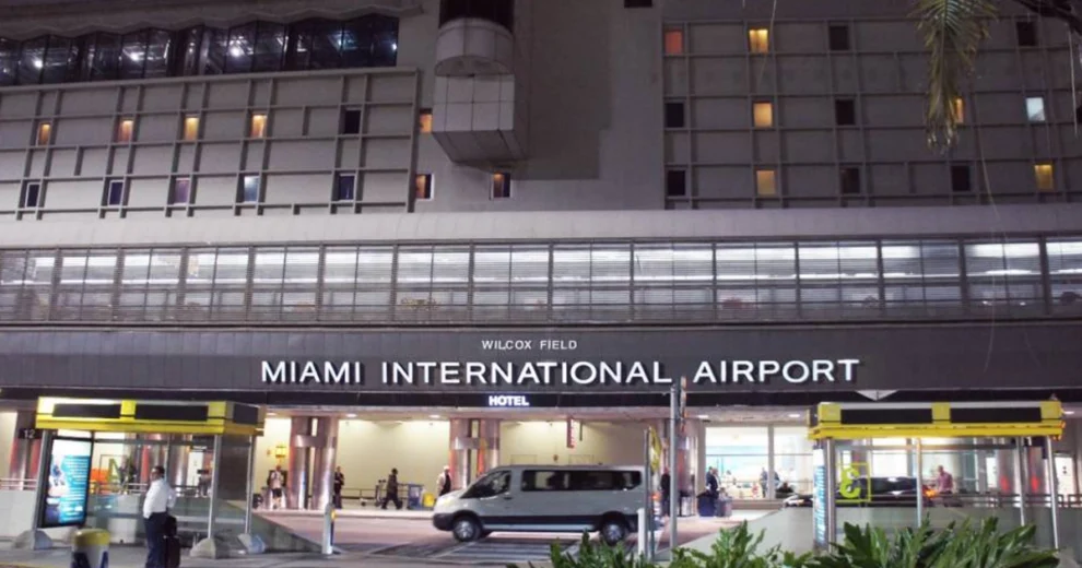 Nighttime exterior view of Miami International Airport’s terminal entrance.