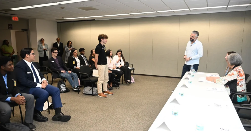 Chairman Anthony Rodriguez Announces the Return of the Youth Engagement Program for 2026 — Applications Now Open for High School Students 1 A participant in the Miami-Dade Youth Engagement Program stands to ask a question during a panel discussion while fellow students and county representatives listen in a conference room.