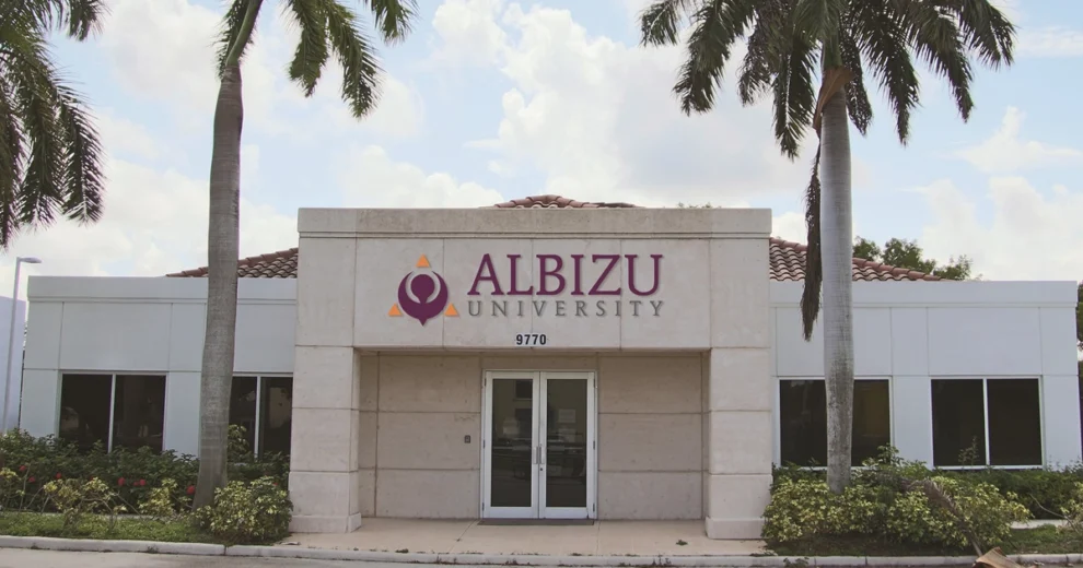 Exterior del edificio del campus de la Universidad Albizu, que muestra el nombre y el logotipo de la universidad sobre la entrada principal.