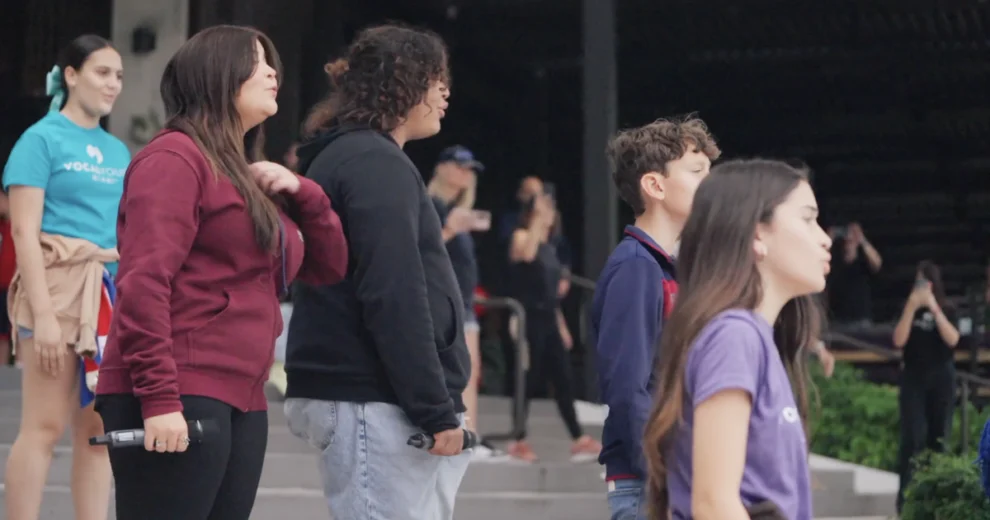 Vocal Youth Miami singers and participants walk together outside River Landing Shops & Residences during a group performance.