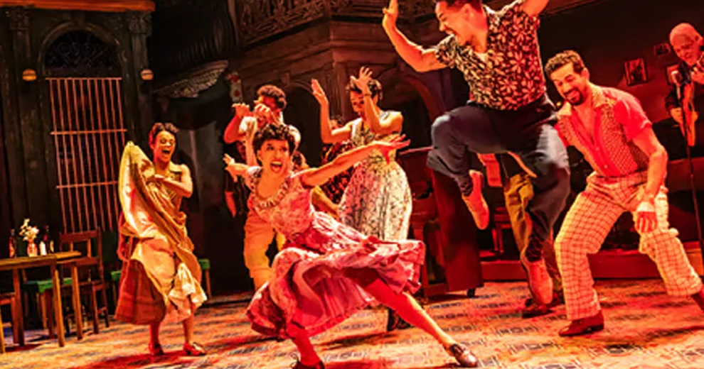 Los artistas bailan con energía en el escenario durante Rhythm & Roots, acompañados por músicos en vivo en una animada representación teatral.