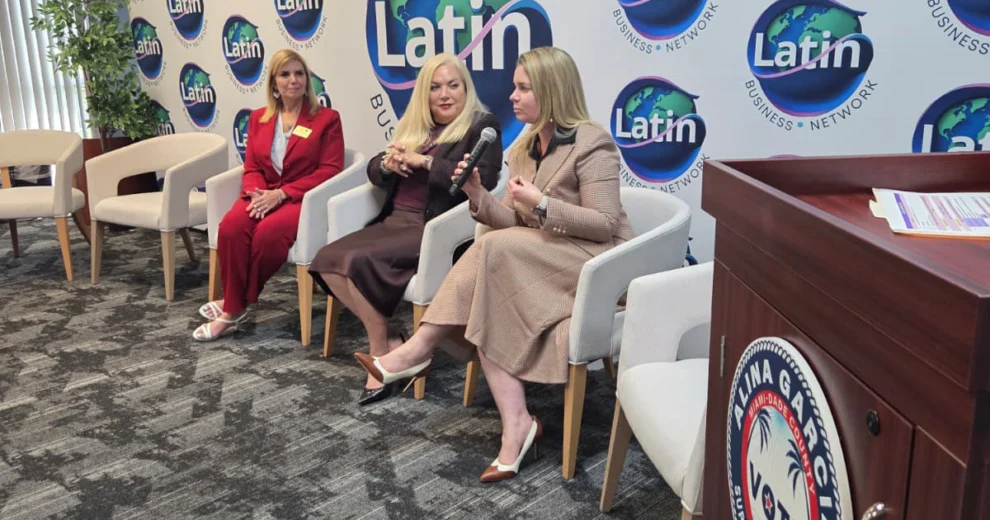 Women Leading Miami reunió a líderes empresariales y educadores electorales en Doral 1 Tres mujeres están sentadas en sillas durante un panel de discusión frente a un telón de fondo de Latin Business Network; una de ellas sostiene un micrófono.