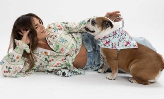 Rosi Rosell acostada de lado con Abigail, la bulldog, luciendo accesorios para mascotas de Angie y Allie.