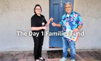 An employee from Care Resource holding house keys and shaking hands with a new resident.