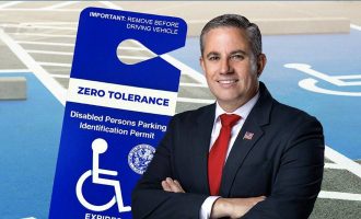 Miami-Dade Tax Collector Dariel Fernandez with a disabled parking permit in the background.