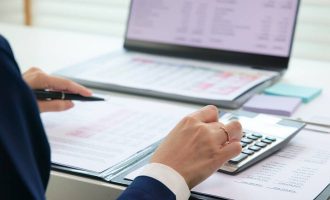 A person sitting at a desk filling out tax forms.
