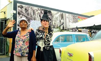 Dos mujeres saludando en la celebración del Día de la Guayabera.