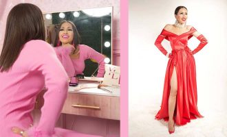 Una mujer con un vestido rosa posa junto a un espejo, mostrando su reflejo de una manera elegante y con estilo.