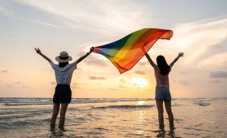 Dos mujeres sosteniendo una bandera del orgullo en Miami Beach.