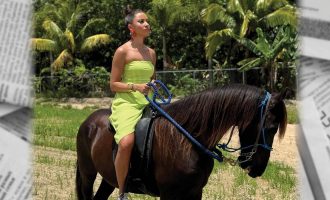 Yli Liriano con un vestido verde sobre un caballo marrón con palmeras al fondo.