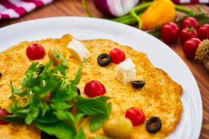 A delicious-looking egg with cheese and vegetables.