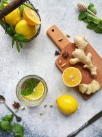 A flat lay of lemon, honey, and ginger as well as other spices.